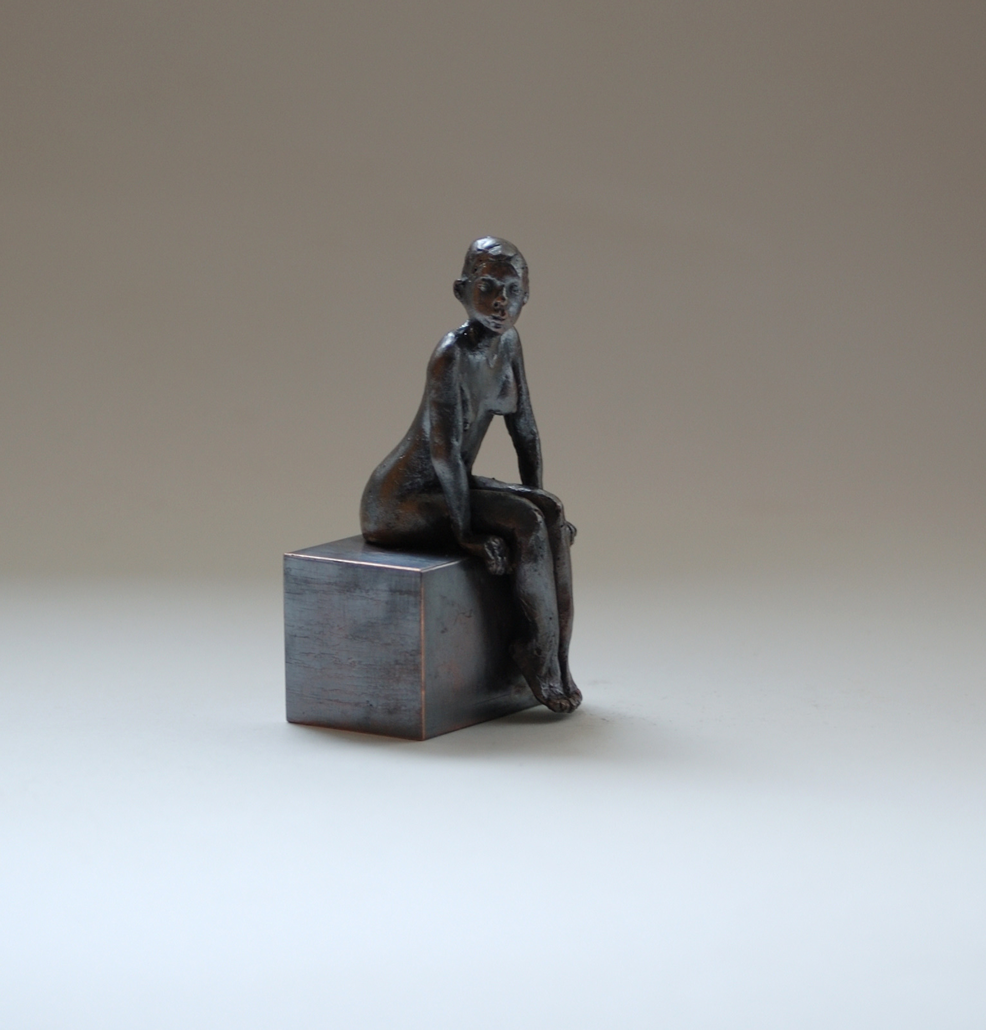 kleine sitzende Frau aus Bronze, dunkel