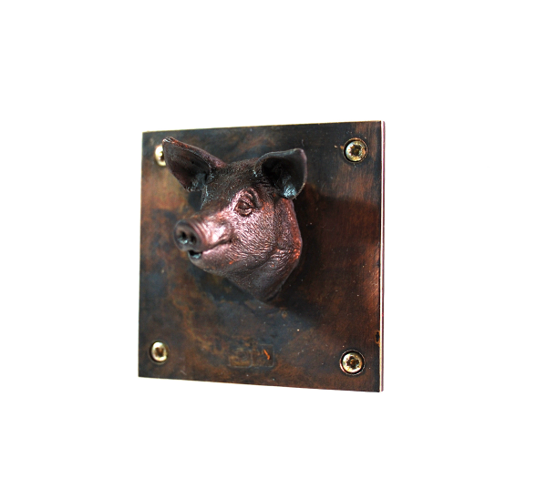 Kleinskulptur Schwein aus Bronze, auf 5 x 5 cm großer Platte sitzt der Schweinkopf mittig und sieht einen frech an