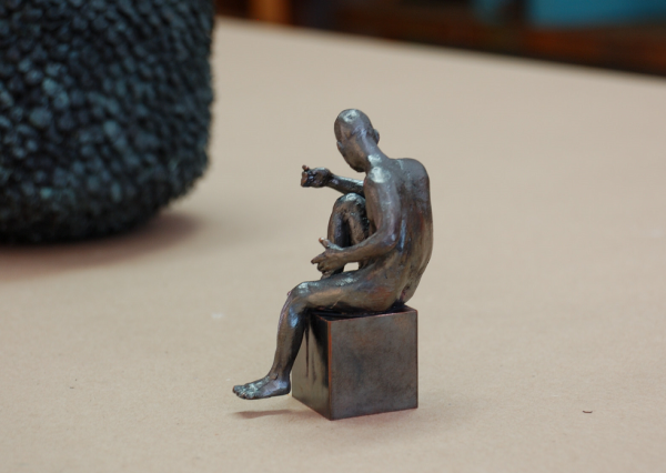 Bronzeakt, männlich, sitzend, im Begriff die Position zu ändern